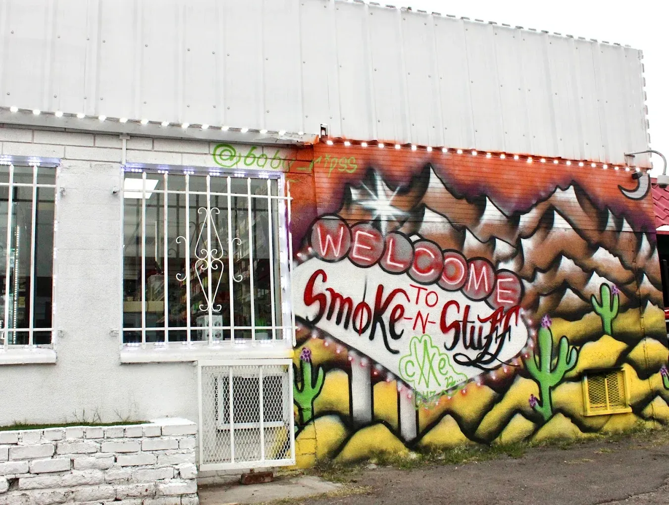 Welcome to Smoke-N-Stuff desert and cactus mural painted on the building