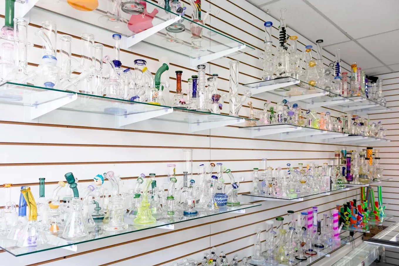 Glass pipes and hand pipes displayed on organized wall shelving